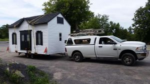 Camion qui tire un cabanon blanc